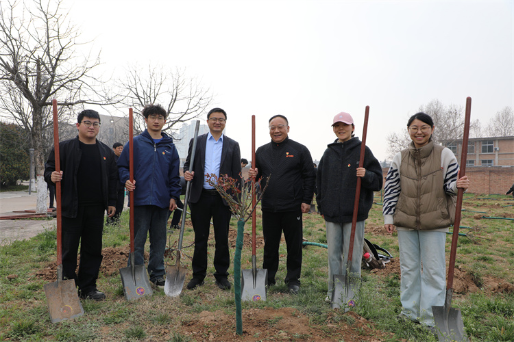 副校长张海成与共同劳作的师生树苗前合影.jpg